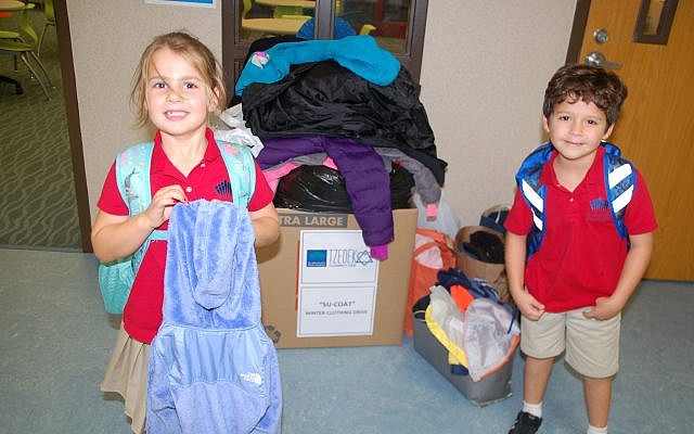 Hazel Halitsky and Rafi Breslav-Siller show how Davis lower school families donated coats to Simple Needs GA during the Su-Coat winter clothing drive.