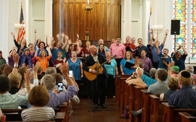 Choir Director Will Robertson plays his guitar along with the choir as they perform at the Piccolo Spoleto Festival in Charleston, S.C.