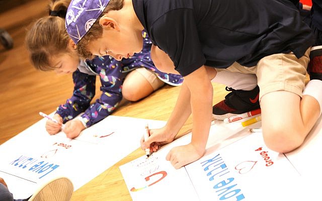 Epstein second-grader Sara Shulman, and third-grader Gerald Kogon, get creative while working on a poster about love.
