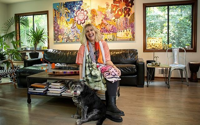 Photos by Duane Stork // Karin Mervis poses with Schnauzer mix, Tanzi, in front of her colorful “Babylon 2” and “Babylon 3.”