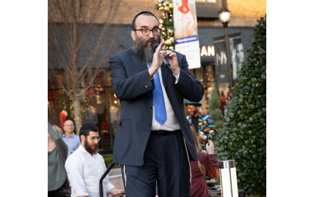 Rabbi Hirshy Minkowicz, director of Chabad of North Fulton, leads the second annual Chanukah celebration at Avalon.