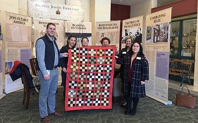 Jeremy Katz of the William Breman Jewish Heritage Museum and Renee Kutner of the Jewish Federation of Greater Atlanta receive a quilt from members of the Oak Grove United Methodist Church.