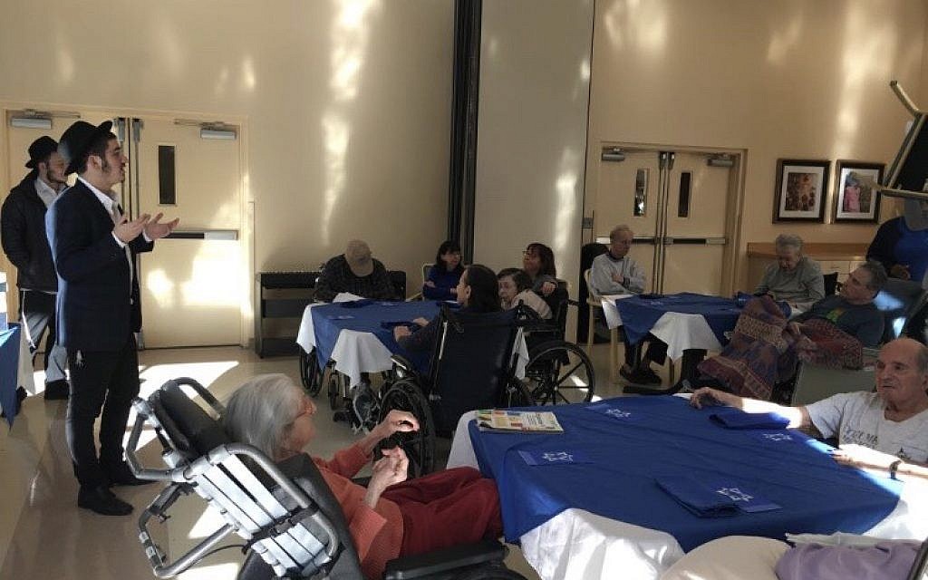 Mendy Grossbaum shares a Chanukah message with senior citizens at The Fountainview Center for Alzheimer’s Disease.