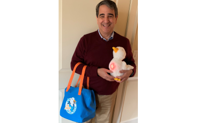 Joey Moskowitz displays the aqua tote bag and duck whose stomach is glowing to show a happy mood.
