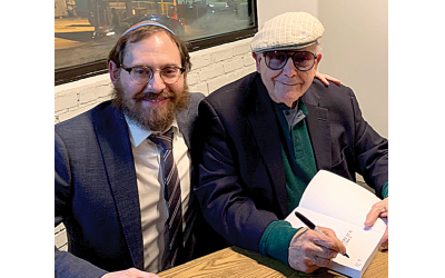 Guest speaker Myron Sugerman enthralled a packed Intown Chabad audience, seen here with Rabbi Ari Sollish, signing his book.
