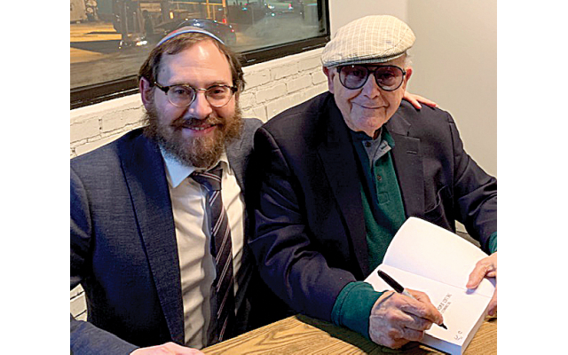 Guest speaker Myron Sugerman enthralled a packed Intown Chabad audience, seen here with Rabbi Ari Sollish, signing his book.