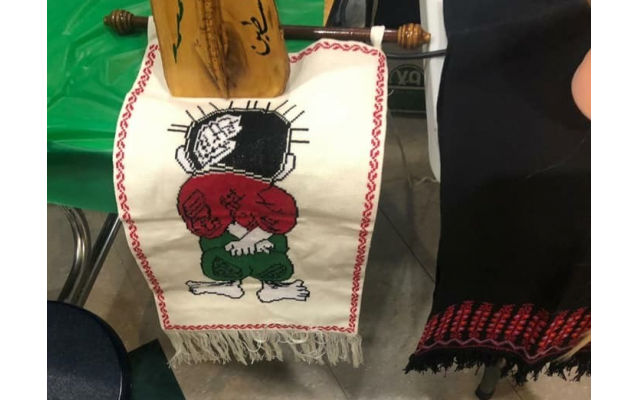 Beside the map is a knit image of “Handala,” a Palestinian boy with his hands beside his back, drawn by Naji al-Ali, the Palestinian political cartoonist.