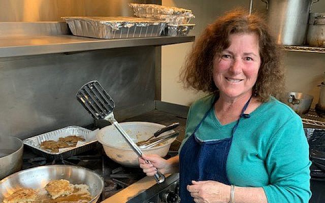Myra Goldberg helps create matzah brie for the contest.