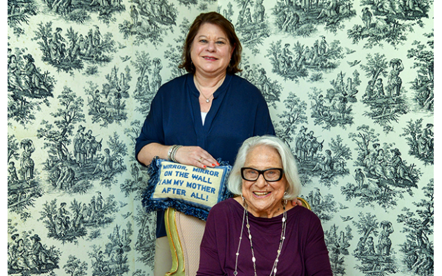 Photos by Duane Stork // Julie and Jean share the joy of Mother’s Day with the pillow that reads, “Mirror, mirror on the wall, I am my mother after all.” Jean needlepointed the pillow.
