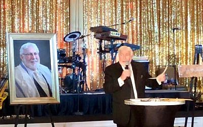 Photo by Bernice Isaac // Man of the hour, Rabbi Lewis takes center stage. Behind him are his portrait and a plaque announcing a new rabbinic suite in his honor.
