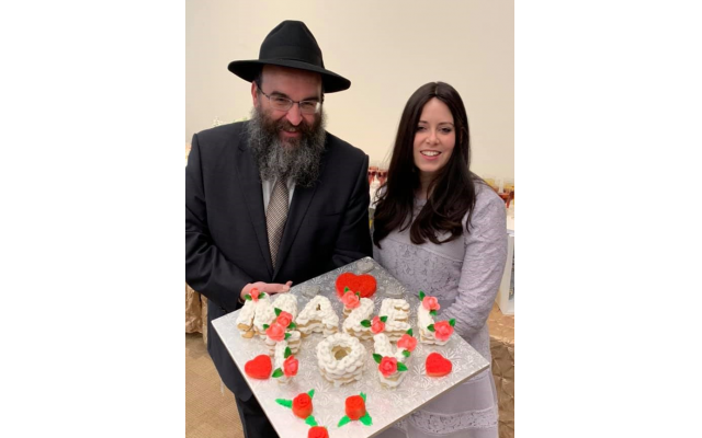 Rabbi and Mrs. Minkowicz hold a dessert display by Jodie Sturgeon of For All Occasions and More catering.