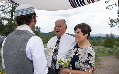 Photo of Gerry and June Neumark renewing their vows under son Jay’s tallit.