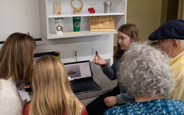Students show visitors how some of the equipment in the Zalik Academy work. Here a student demonstrates 3-D printing.