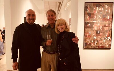 Gallery owner Bill Lowe welcomes Steve Human and Joanne Ackerman alongside “Pure American.” Taupin’s 2017 work was made from flag material and is priced at $28,500.