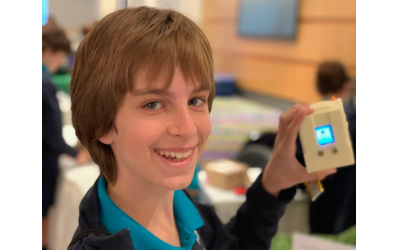 Micah Kopelman proudly displays the mini Mac computer created with a 3D-printed computer body and coded with Python, a programming language platform.