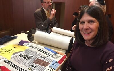 Karen Lansky Edlin stands with the Ozorkow Torah and its mantle, which she designed. Standing behind her is Rabbi Neil Sandler. The Torah, which her parents presented to the congregation in 1977, was rededicated Jan. 5.