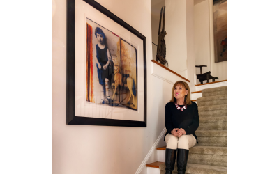Multifaceted artist Lesley Price relaxes on her staircase wearing a colorful acetate necklace by South African Beverley Price. Beside her is one of the postcards preserved from her father's youth in Germany.