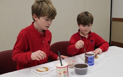Josh and Noah Friedberg decorate cookies as a community service project.