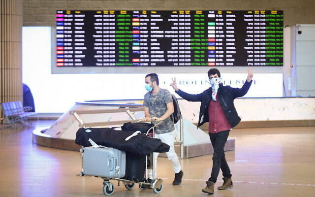 People wear face masks arrive at Ben Gurion International Airport on March 11, 2020. (Flash90)
