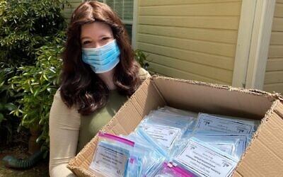 Bracha Slavaticki, the co-director of Chabad Decatur, with a box of masks for community distribution.