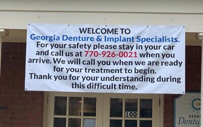 Dr. Warren Berne has a banner in front of his dental office explaining the change in waiting room procedure.