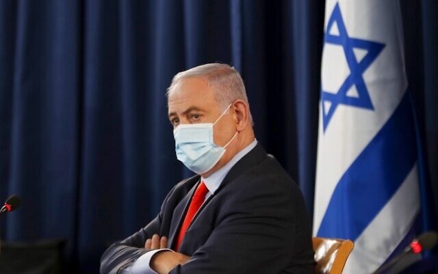 Israeli Prime Minister Benjamin Netanyahu, wearing a protective face mask, chairs the weekly cabinet meeting in Jerusalem on May 31, 2020. (Photo by RONEN ZVULUN / POOL / AFP)