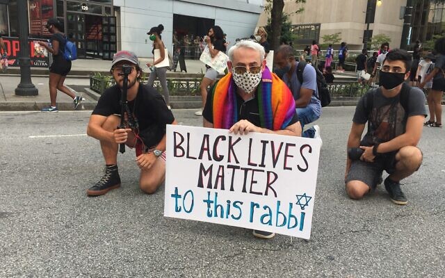 Rabbi Joshua Lesser of Congregation Bet Haverim takes a knee during a June 4 interfaith march against racism that began near the state capitol and ended outside the CNN Center in downtown Atlanta. //Photo credit: Audrey Galex.