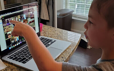 First-grader Reuven Simon learns online at home.