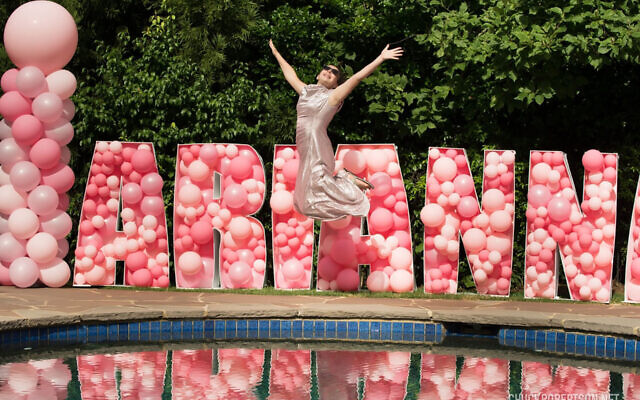 Photo credit: Chuck Robertson Photography // Arianna catches air in front of a background spelling out her name in balloons. Balloon columns by Balloons Over Atlanta.