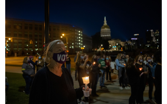 A woman holds a candle in memory of the late Justice Ginsburg at a candlelight vigil in her memory. // Nathan Posner for the AJT.