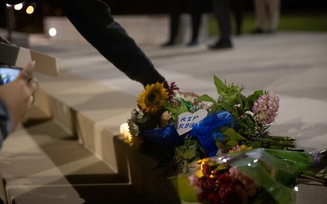 People place candles and flowers at a makeshift memorial honoring the late Supreme Court Justice Ruth Bader Ginsburg at the Georgia Supreme Court building. // Nathan Posner for the AJT.