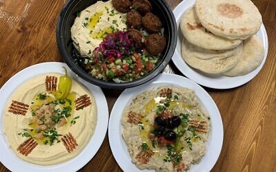 The falafel platter is a popular entrée shown here with fresh-from-scratch hummus and baba ghanoush. Note the creative garnish detail.