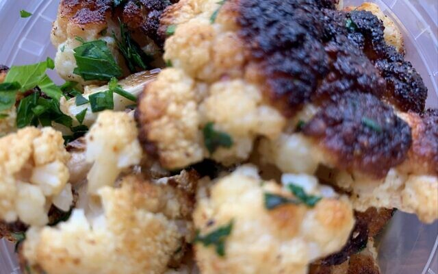 The roasted cauliflower is scorched and flavored with parsley and olive oil.