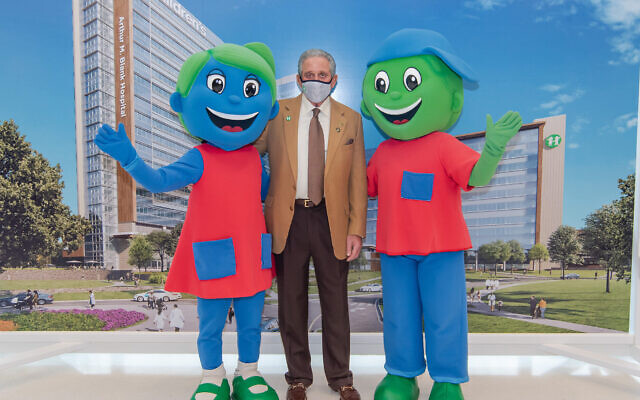 Arthur Blank is committed to giving away at least half of his $6 billion personal fortune during his lifetime. He’s pictured here with CHOA’s mascots Hope and Will.