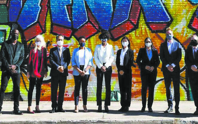 Representatives from nine consulates in Atlanta and representatives from Atlanta city government line up in front of the mural honoring frontline workers in the pandemic.