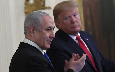 US President Donald Trump, right, looks over to Prime Minister Benjamin Netanyahu, left, during an event in the East Room of the White House in Washington, January 28, 2020, at which Trump unveiled his "Peace to Prosperity" vision for an Israeli-Palestinian accord. (AP/Susan Walsh)