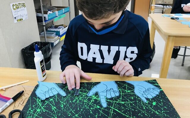 Using American Sign Language, Davis seventh grader Adam places his traced hands in a collage.