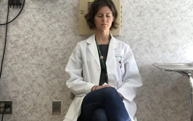 This primary care physician meditates, detached from people around her.