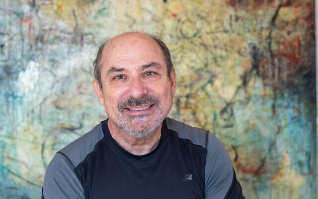 Attorney Jeff Kaufman poses in front of a large Mark Perlman encaustic.