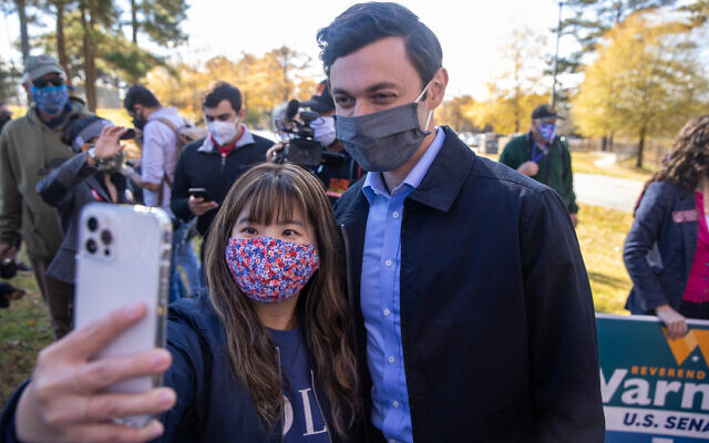 Nathan Posner // Jon Ossoff takes a selfie with a young supporter during a march to support  early voting in Gwinnett County on December 14th.