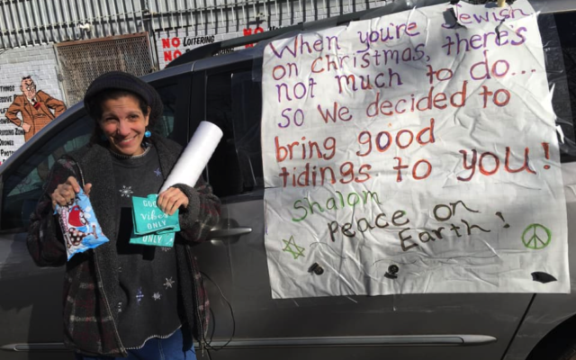 Rivkah Eidex holds up one of the bags being given to the homeless next to the “Christzmah” mobile.