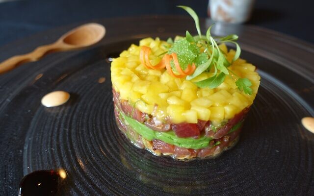 Tuna Tar Tar: cubed tuna “round” with chives, fried onions, avocado and sesame oil topped with mango.