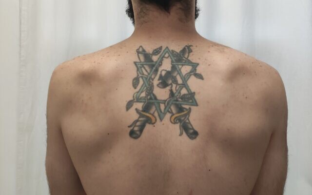The back tattoo of David Eisenberg, a Sandy Springs native now living in Israel, pays homage to Israel: a Star of David, crossed swords with olive branches all intertwined.