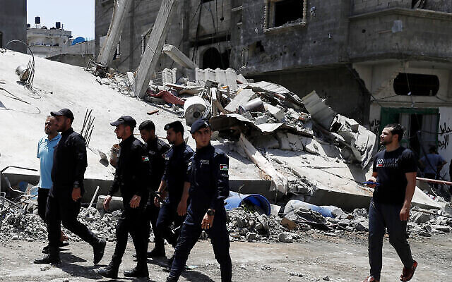 Hamas police officer secure the rubble of destroyed residential building which was hit by Israeli airstrikes, in Beit Lahiya, Gaza Strip, Thursday, May 20, 2021. (AP Photo/Adel Hana)