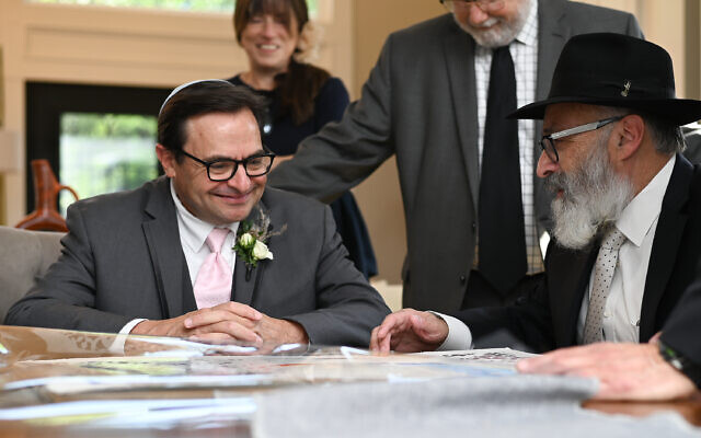 Beth Intro Photography // Rabbi Yossi New signs the ketubah with Jimmy looking on.
