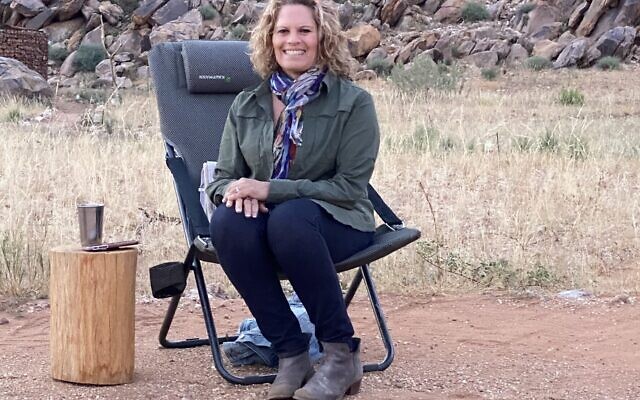 Alli Allen sits near a campfire last month in Namibia.
