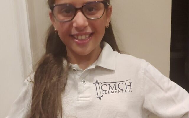 Nine-year-old Raizel Isaacs models her new Chaya Mushka shirt.