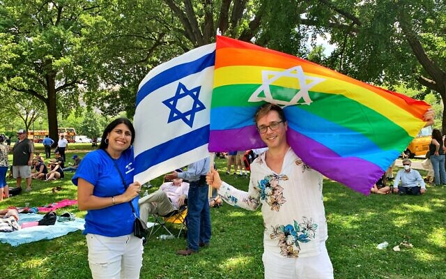 A pride flag with a Star of David is waved beside Israel’s blue and white symbol.