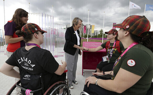 In this Thursday, Aug. 23, 2012 photo, Eve Loeffler, daughter of the founder Paralympic games Ludwig Guttman, meets Jessica Vliegenthart, second right, Elaine Allard, right, Tamara Steeves, second left, members of the Canadian Paralympic women’s wheelchair basketball team, at the athletes village at the Paralympic park. (AP Photo/Alastair Grant)