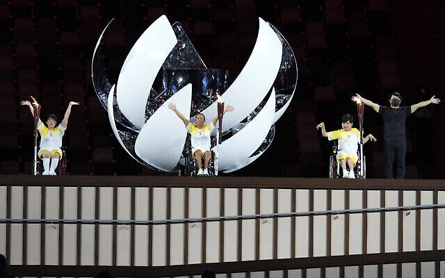 Japan’s Yui Kamiji, centre, Shunsuke Uchida, right, and Karin Morisaki prepare to light the Paralympic cauldron during the opening ceremony for the 2020 Paralympics at the National Stadium in Tokyo, Tuesday, Aug. 24, 2021. (AP Photo/Shuji Kajiyama)